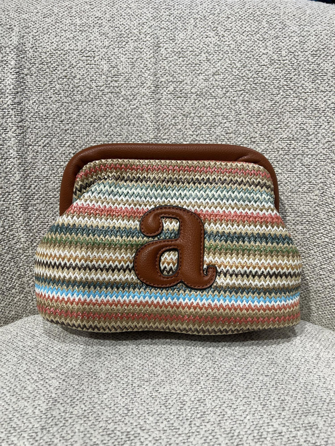 Raffia clutch med flerfargede striper og brun skinn bokstav &