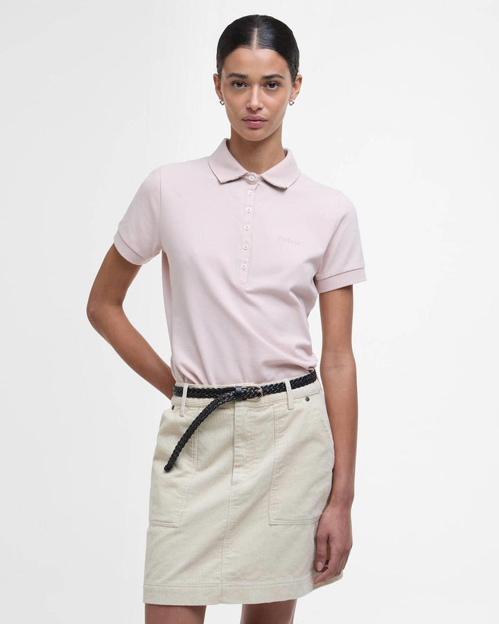 Lys rosa poloskjorte med knappelukking og polokrage, frontsett på modell med beige skjørt