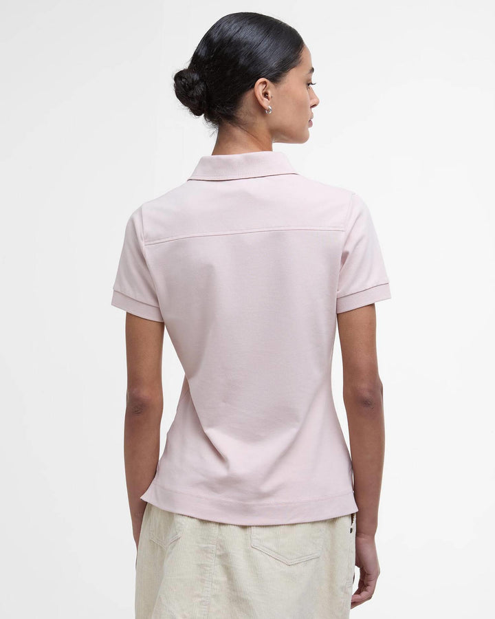 Bakside av lys rosa poloskjorte med kort erm og klassisk piqué-struktur på modell