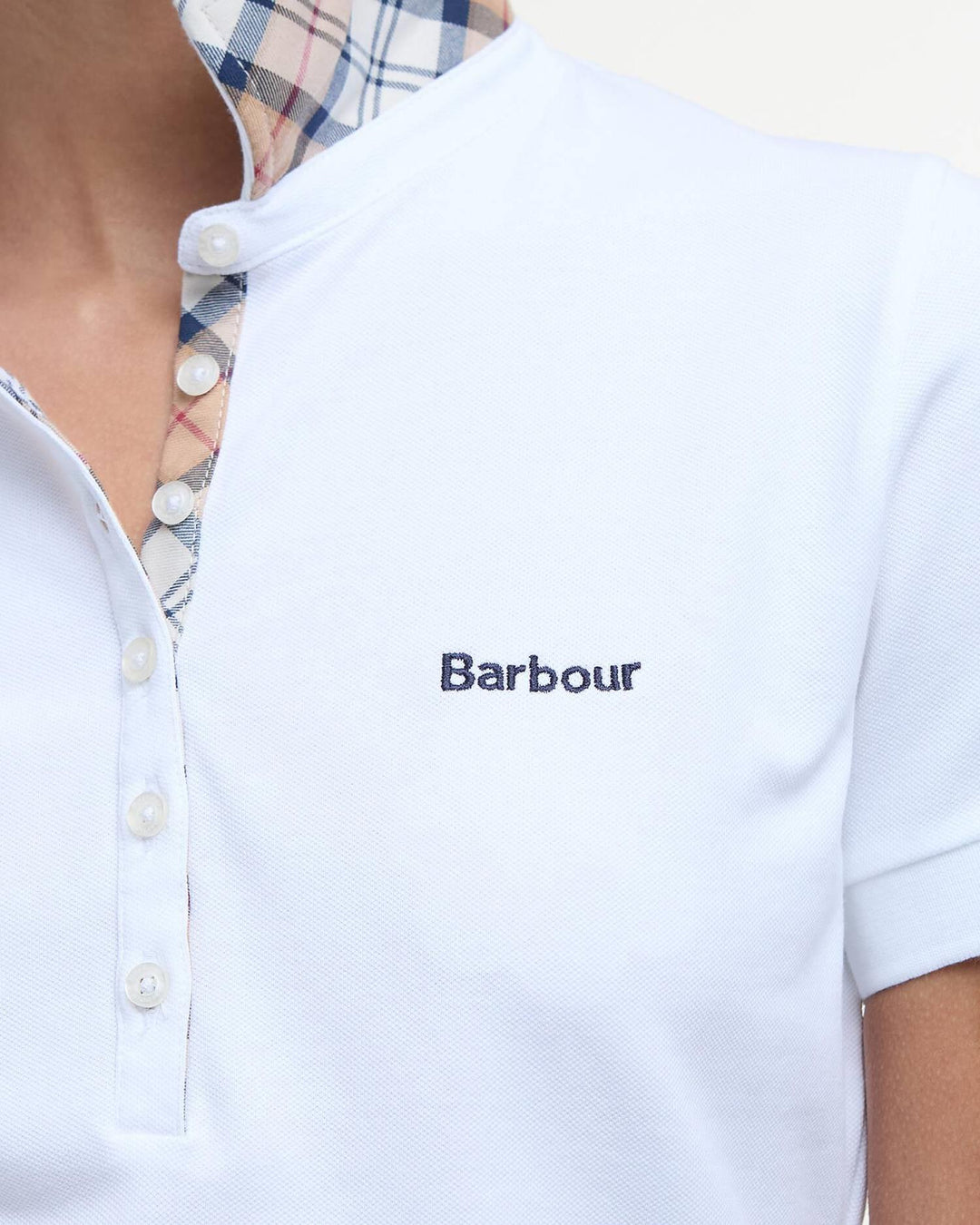 Hvit poloskjorte med Barbour-logo og rutet kragefôr, frontsett på modell med fokus på overkropp