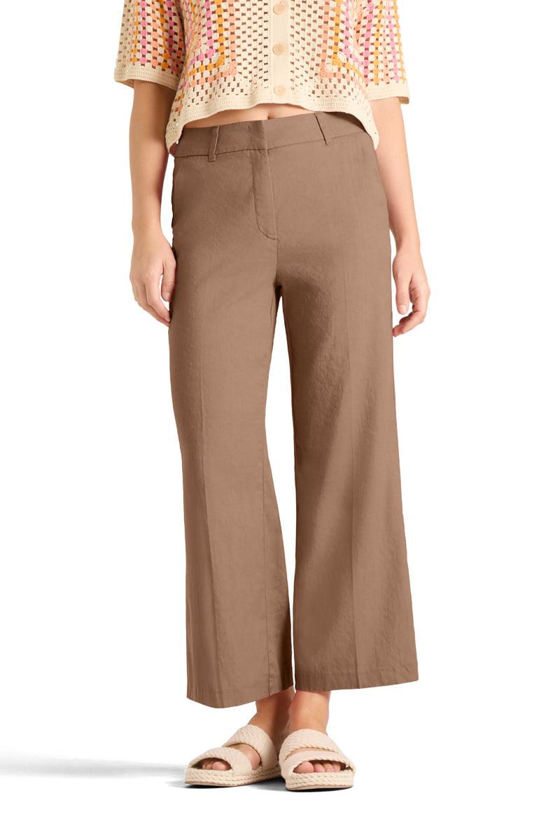 Beige bukser med vid benkutt og knappelukking, frontsett på modell med strikketopp og sandaler
