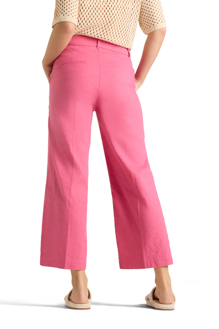Bakside av rosa linbukser med vide ben og lommer, på modell med beige strikketopp
