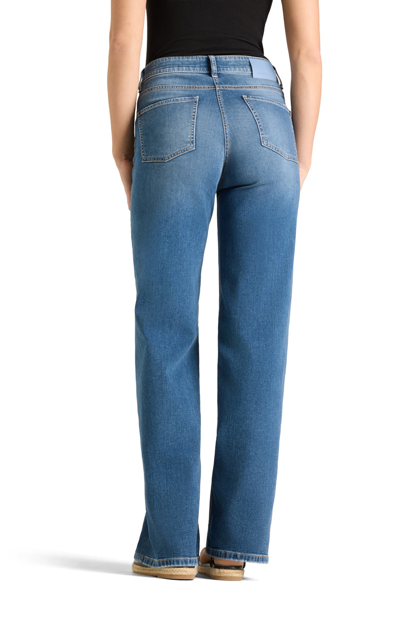 Bakside av medium blå jeans med høy linning, baklommer og rett vid benkutt på modell