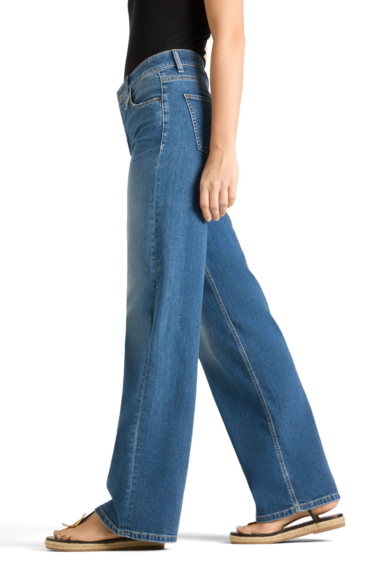 Sidevinkel av denimbukser med vid benkutt og høy linning på stående modell