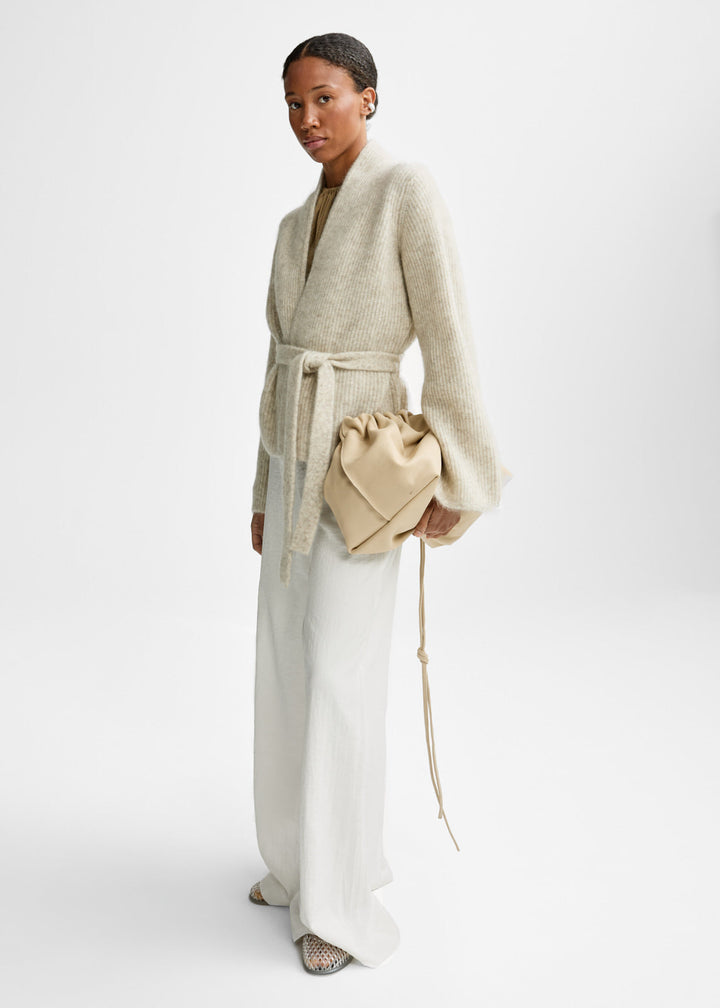 Christian Aks hvetebeige cardigan - på modell fra siden