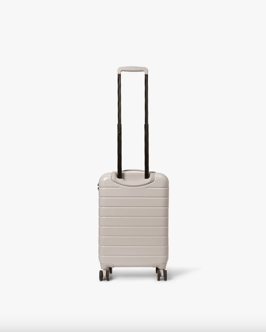 Pastel beige hardskall kabinkoffert med uttrukket teleskophåndtak, bakside med fire hjul synlig