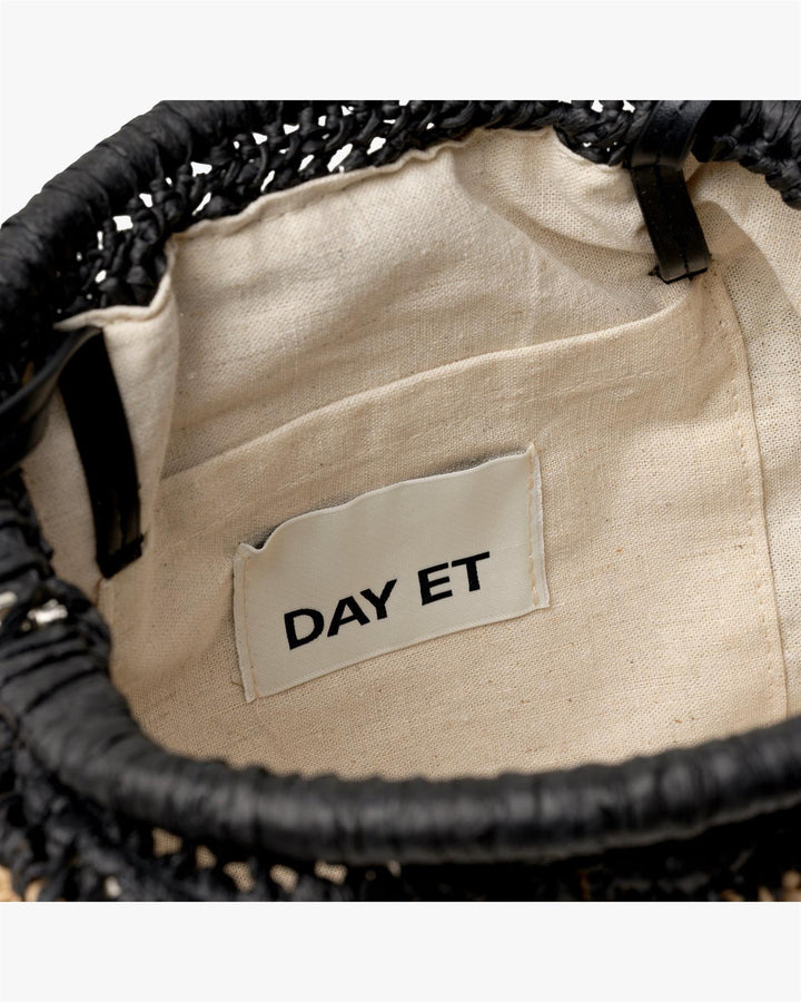Innvendig detaljbilde av clutch med naturfarget fôr og DAY ET merkelapp i lomme
