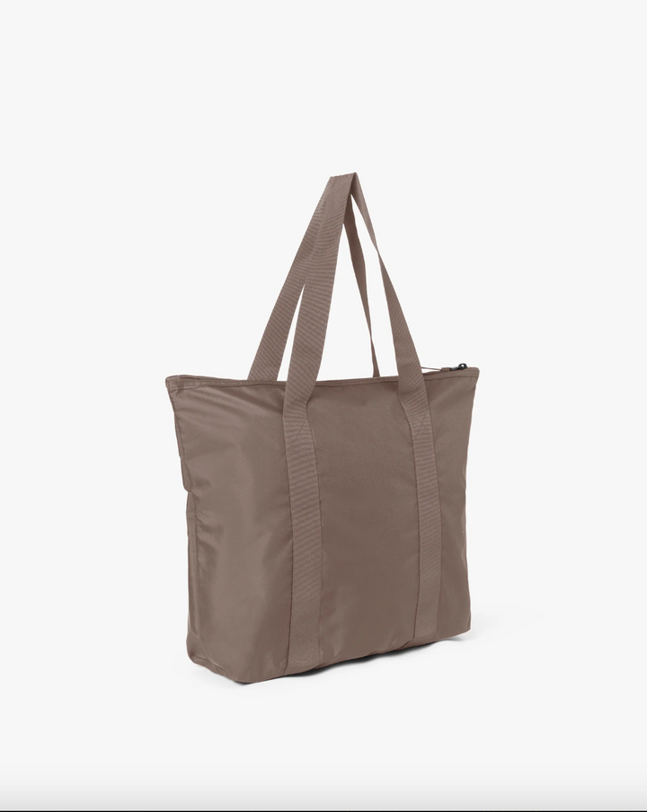Brun shoppingbag i nylon med to bærehåndtak og glidelås, sidevinkel mot lys bakgrunn