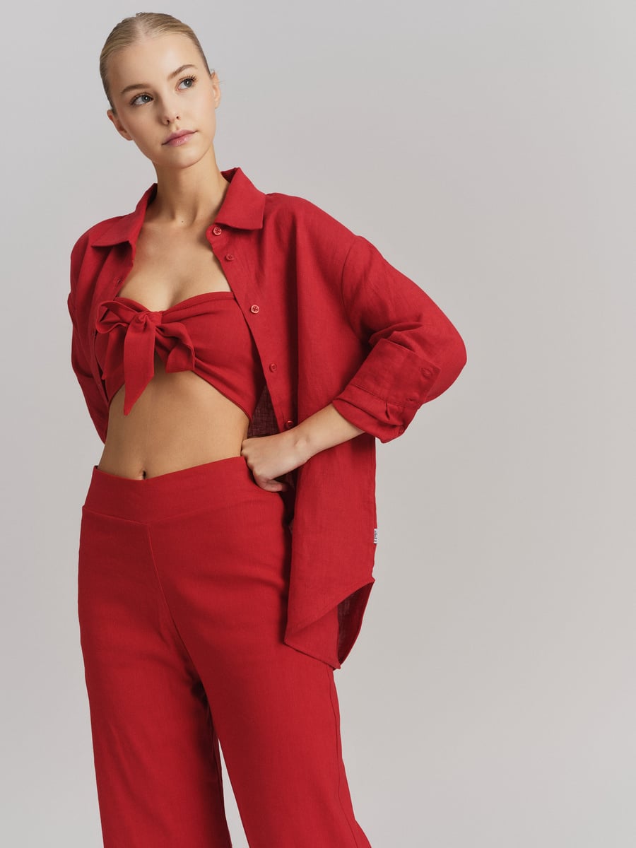 Røde bukser med høy linning og rød crop top med skjorte, frontsett på modell i studio