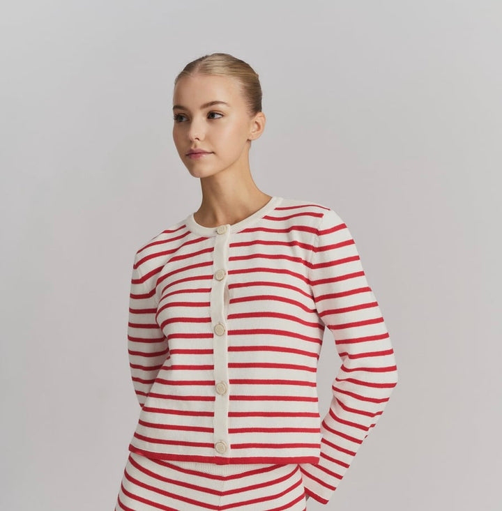 Hvit cardigan med røde striper og hvite knapper, frontsett på modell i studio