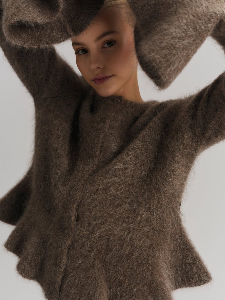 Brun chunky cardigan med dramatiske bell-sleeves, frontsett på modell med armene løftet