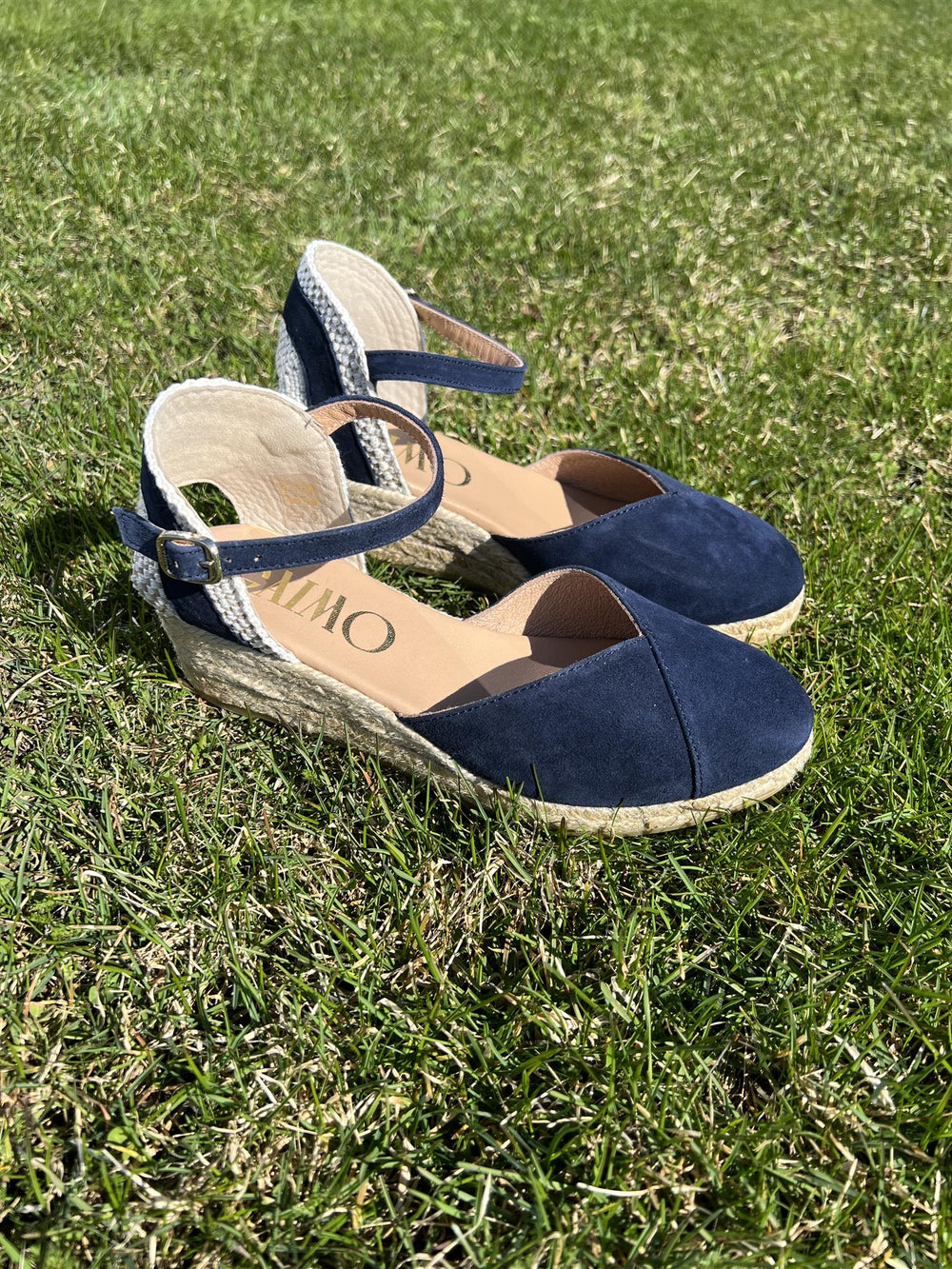 Marineblå espadrille kilehæl sandaler med ankelrem på gressbakgrunn, sidevinkel med begge sko