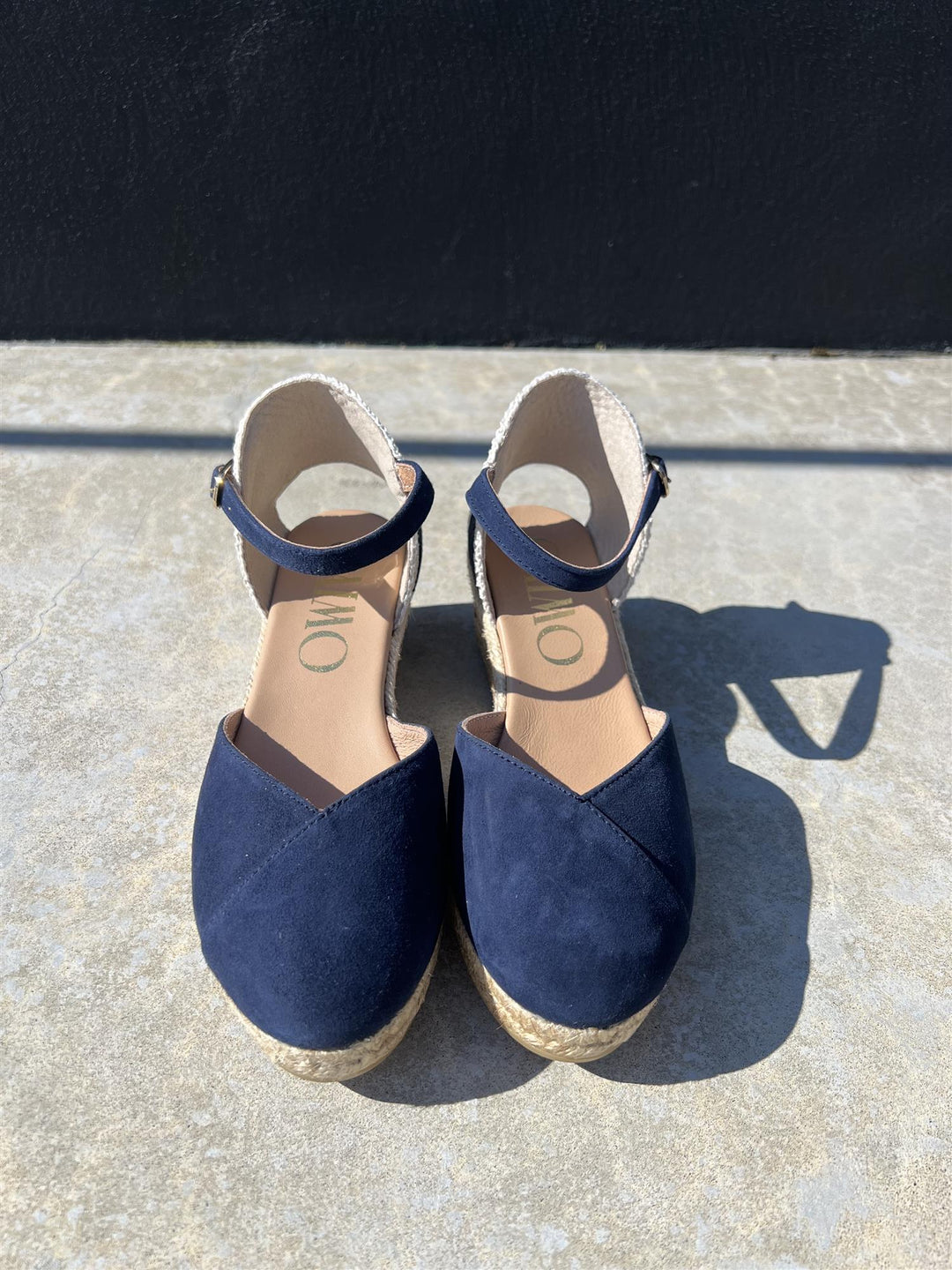 Marineblå espadrille kilehæl sandaler med ankelrem, frontsett på grå steintrapp i sollys