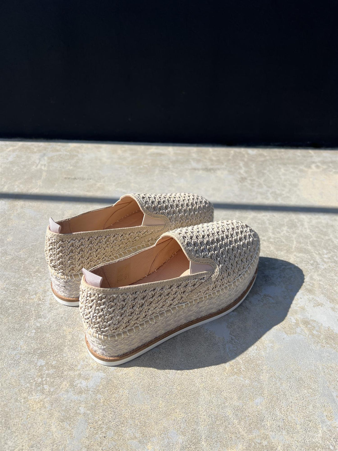 Espadriller med heklet overside og platåsåle, bakvinkel på steingulv i sollys