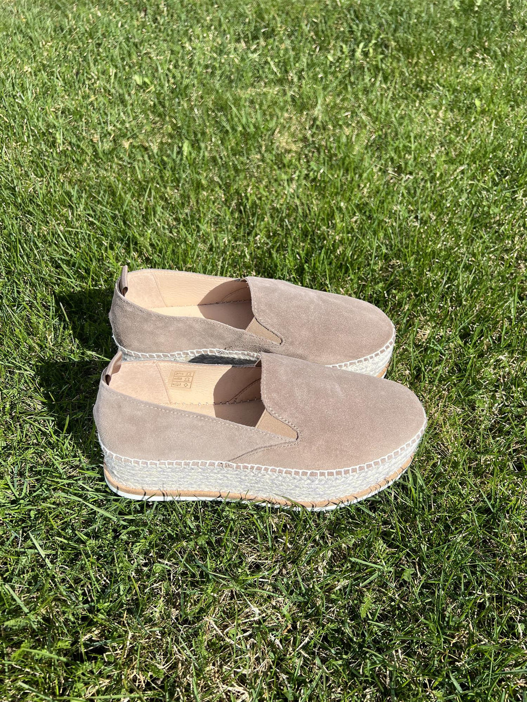 Taupe espadrillesko med jute-såle og pull-tab, sidevinkel på gressbakgrunn i sollys