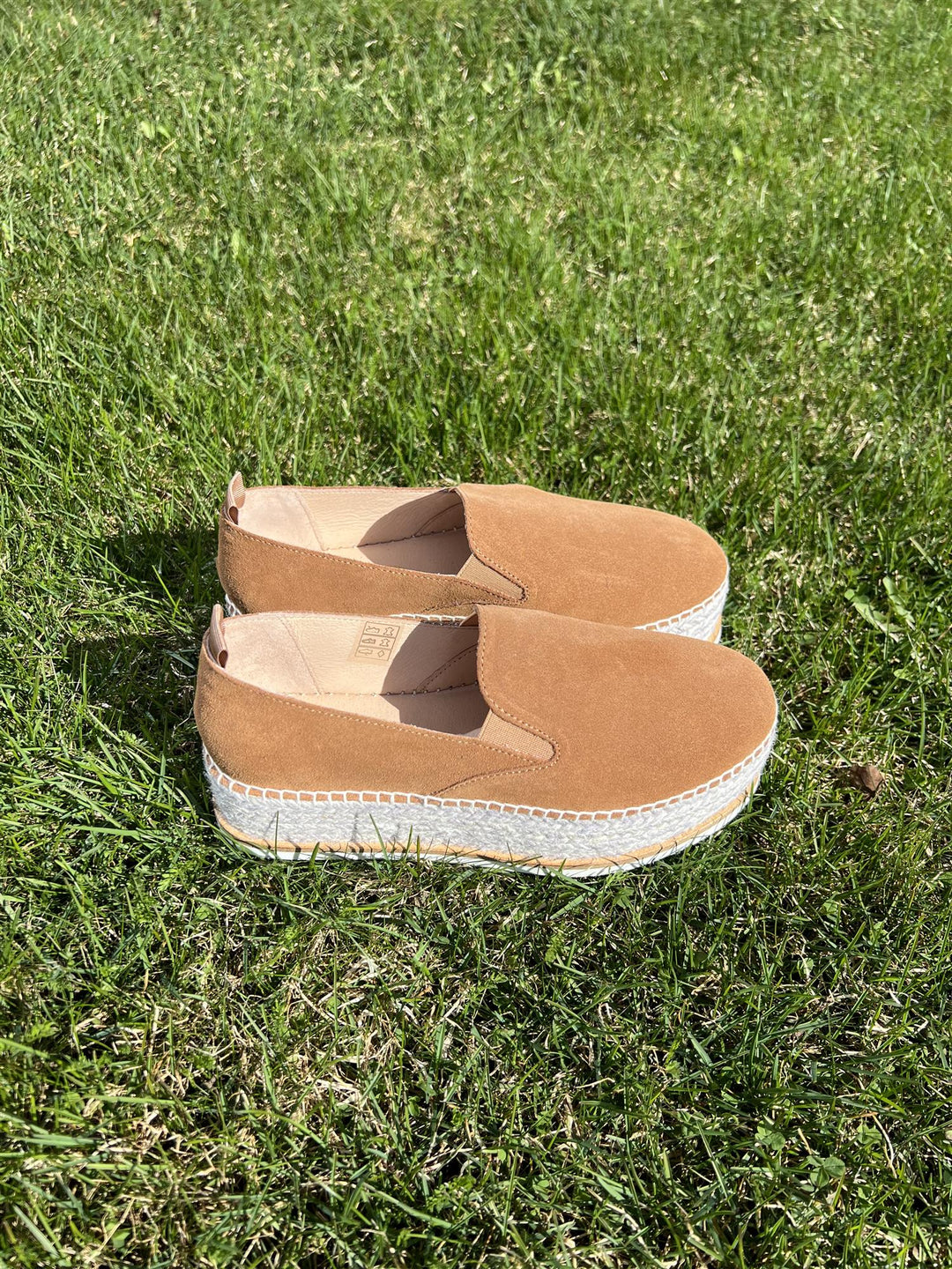 Brune espadrille slip-on sko med jute-såle, sidevinkel på gressbakgrunn i sollys