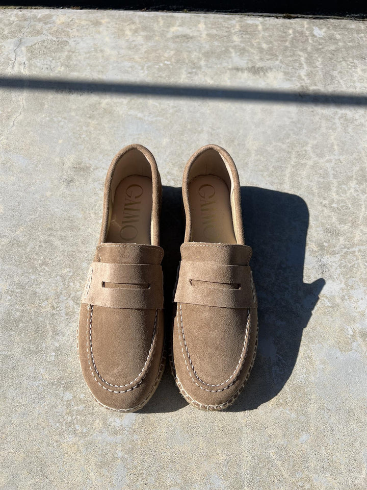 Cuoio loafers i semsket skinn med penny loafer-rem, ovenfra på betongunderlag i sollys