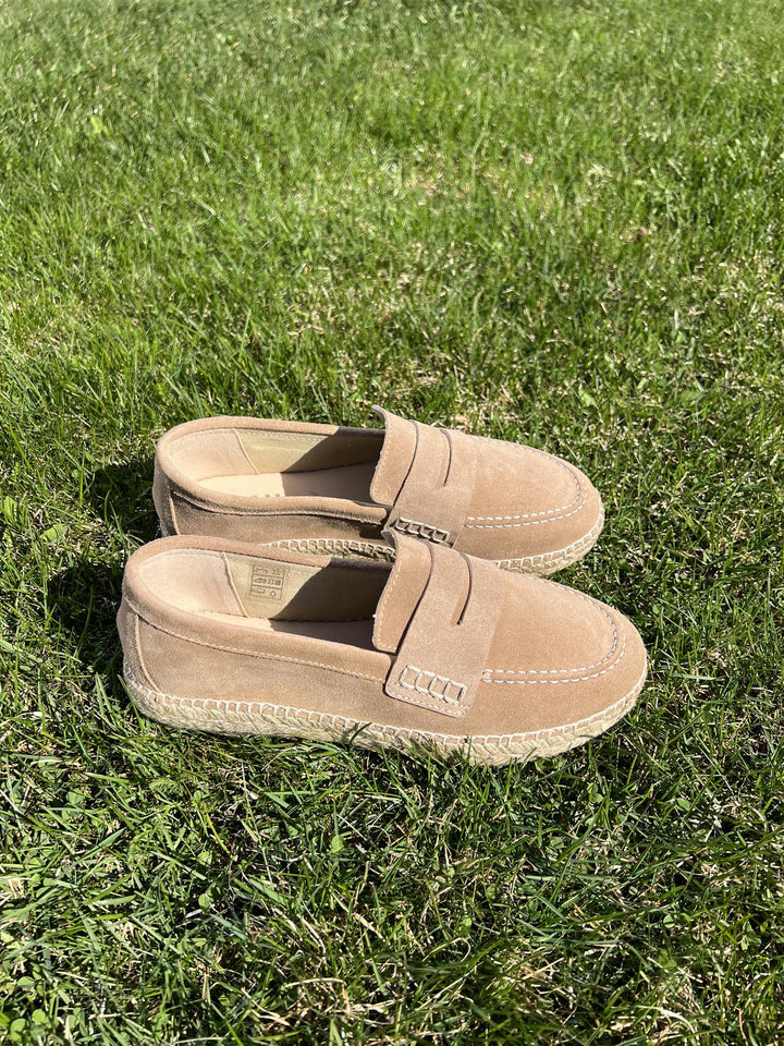 Beige semsket loafers med espadrille-såle og penny loafer-rem, fotografert på gressbakgrunn ovenfra