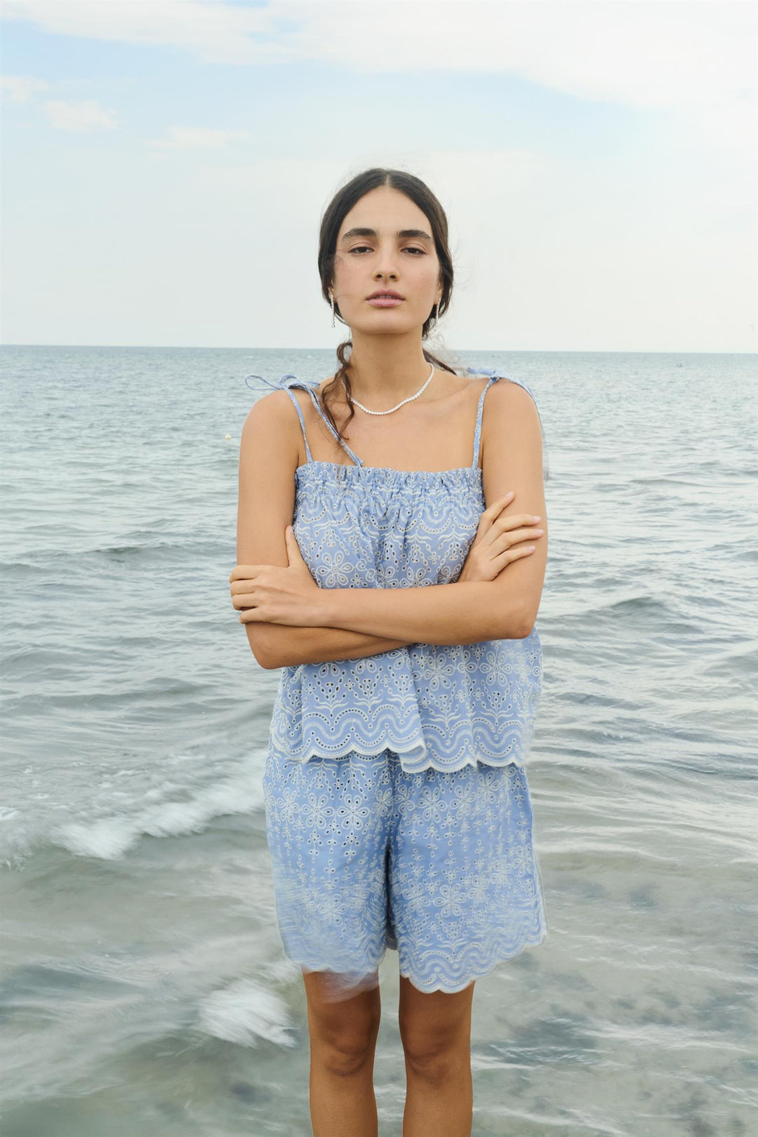 Lyseblå broderte shorts med matchende topp, frontsett på modell ved vannkanten