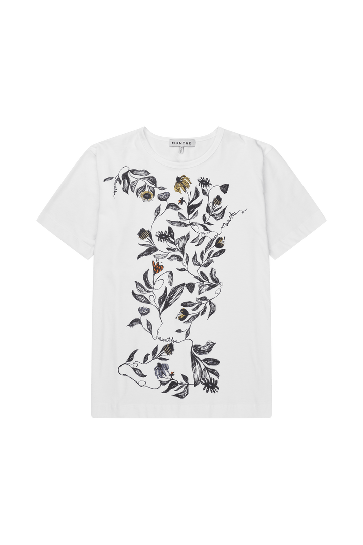 Hvit t-skjorte med botanisk blomstertrykk i svart-hvitt med gule accenter, frontsett flat lay