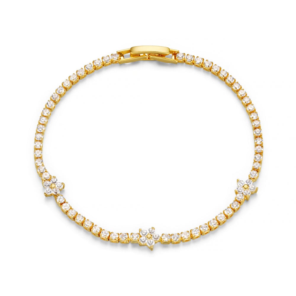 Gulltonet tennis armbånd med cubic zirconia steiner og blomsterdetaljer, flat lay ovenfra mot hvit bakgrunn