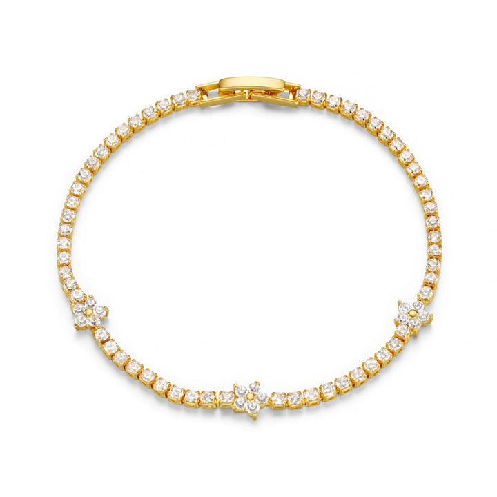 Gulltonet tennis armbånd med cubic zirconia steiner og blomsterdetaljer, flat lay ovenfra mot hvit bakgrunn