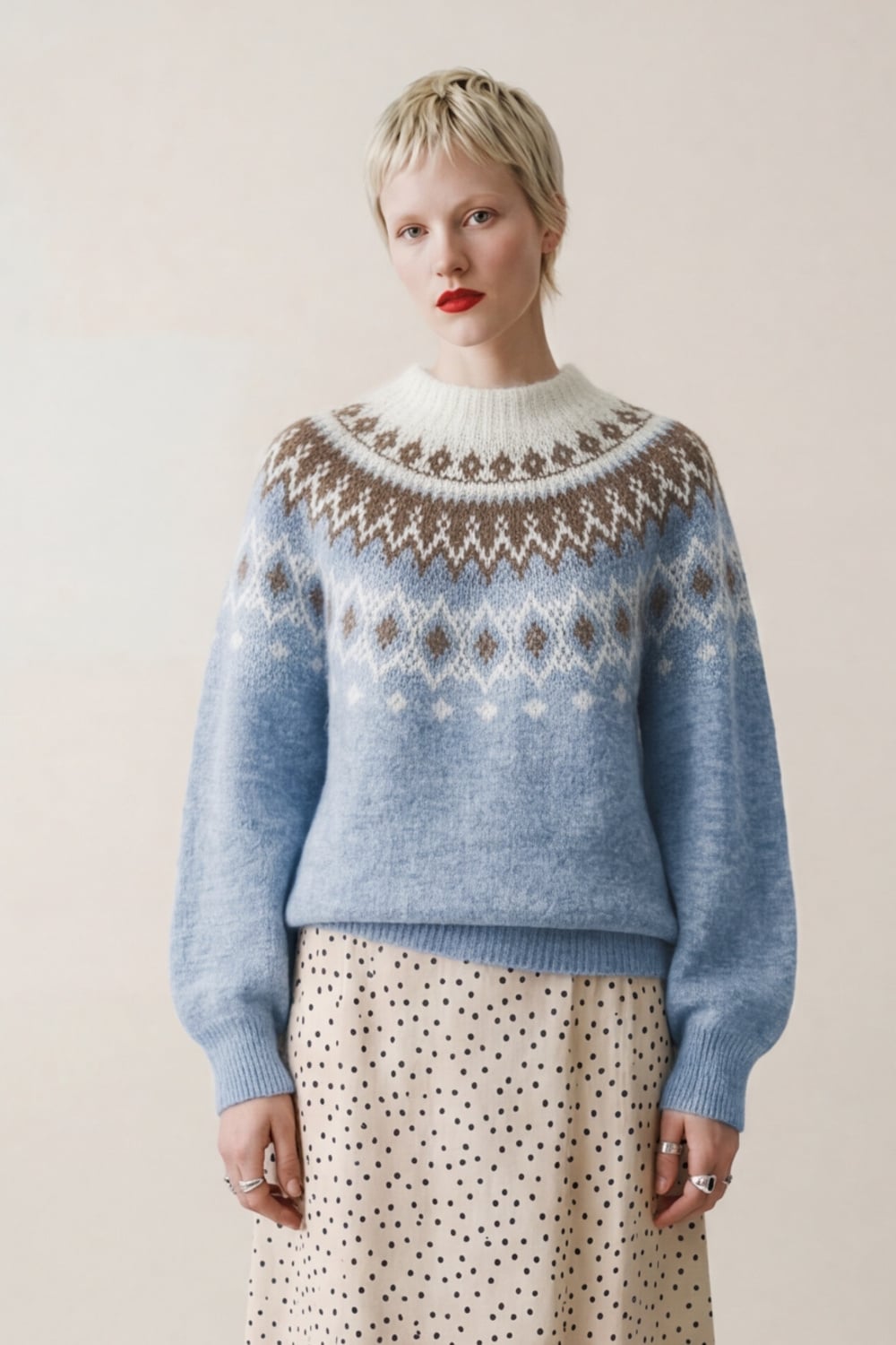 Himmelblå genser med fair isle-mønster, frontsett på modell med prikket skjørt under